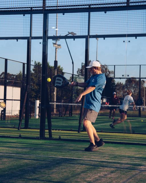 A rally in progress on a floodlit court